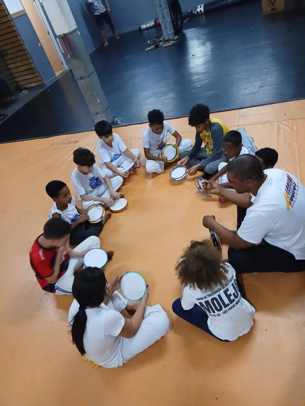 Crianças sentadas em roda durante aula no CT Furacão